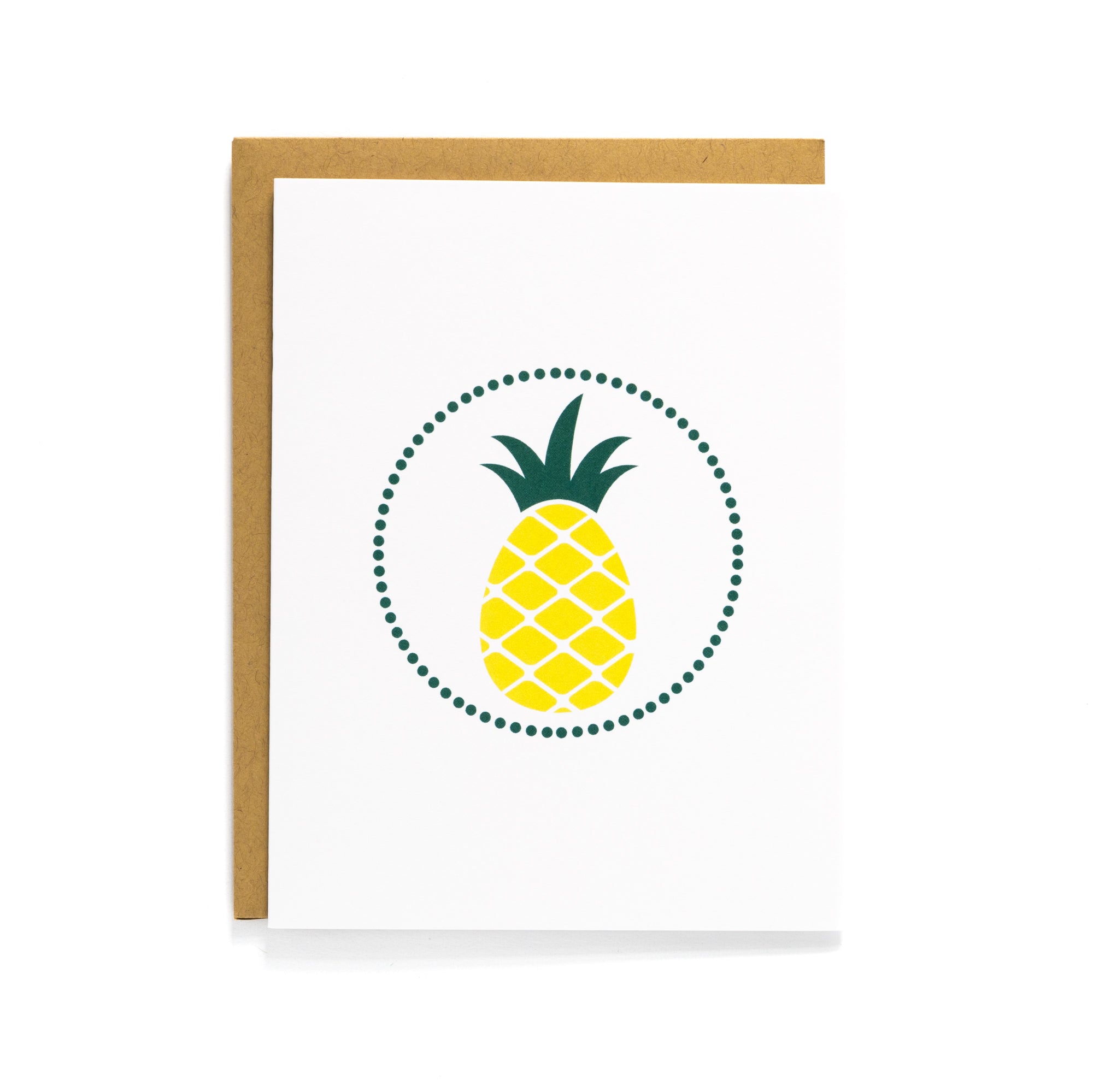 A white card with a yellow pineapple design in a dotted circle, paired with a kraft envelope.