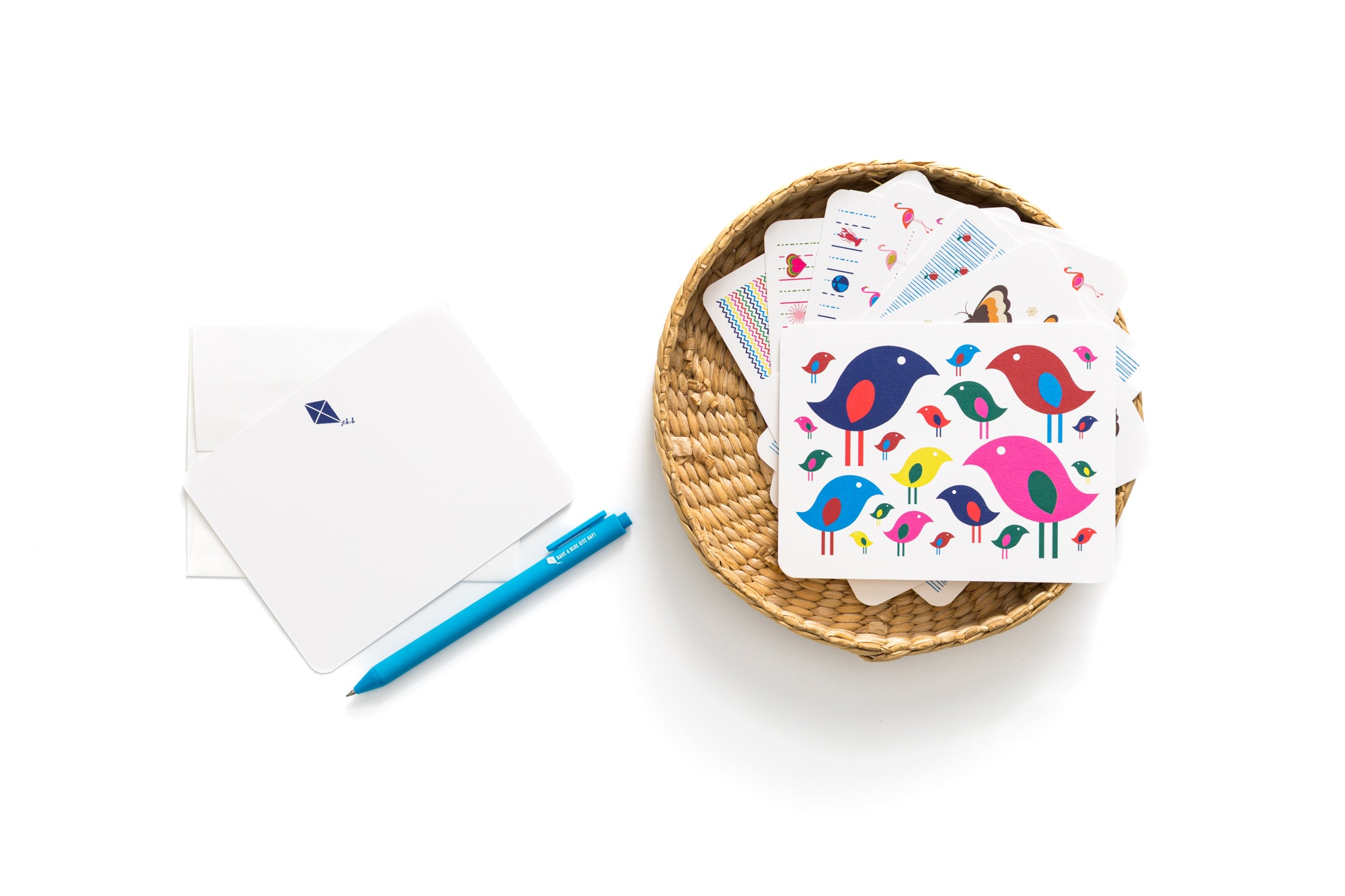 Set of 6 colorful kite-themed flat cards with coordinating envelopes and a blue pen on white background.