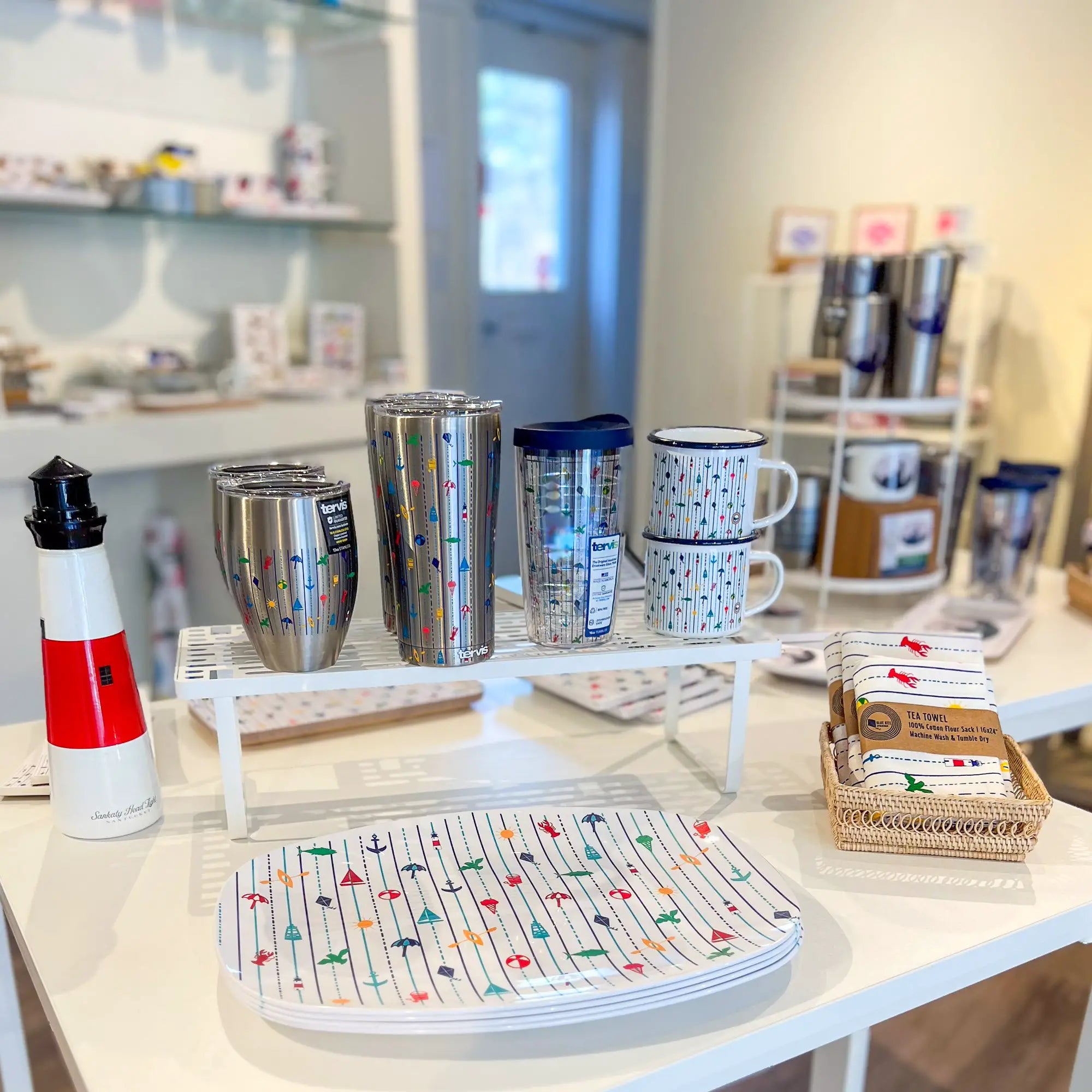 Trays, Tervis tumblers, tea towels, and enamel mugs with beachy seaside illustration