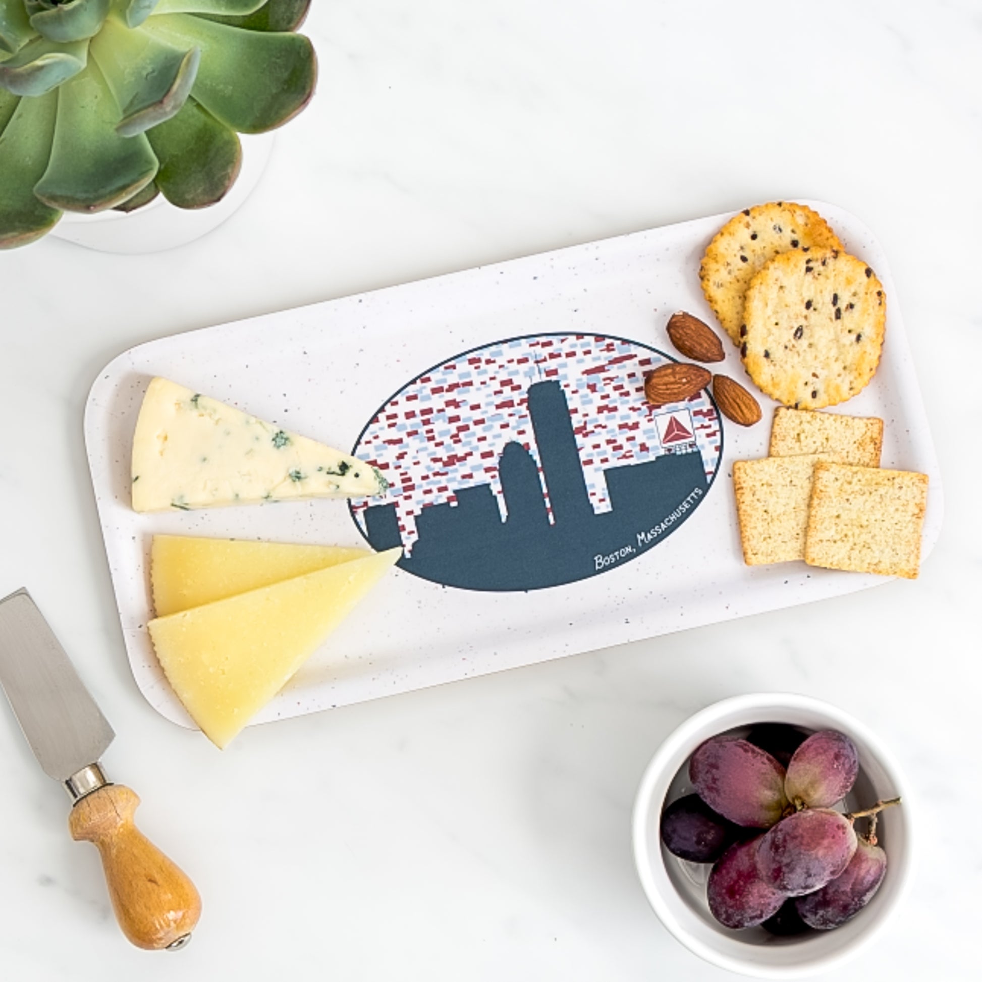 Cheese board of assorted cheese and crackers on birch tray with Boston Skyline pattern