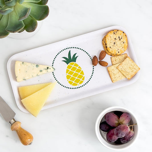 Cheese board of assorted cheese and crackers on birch tray with retro pineapple 