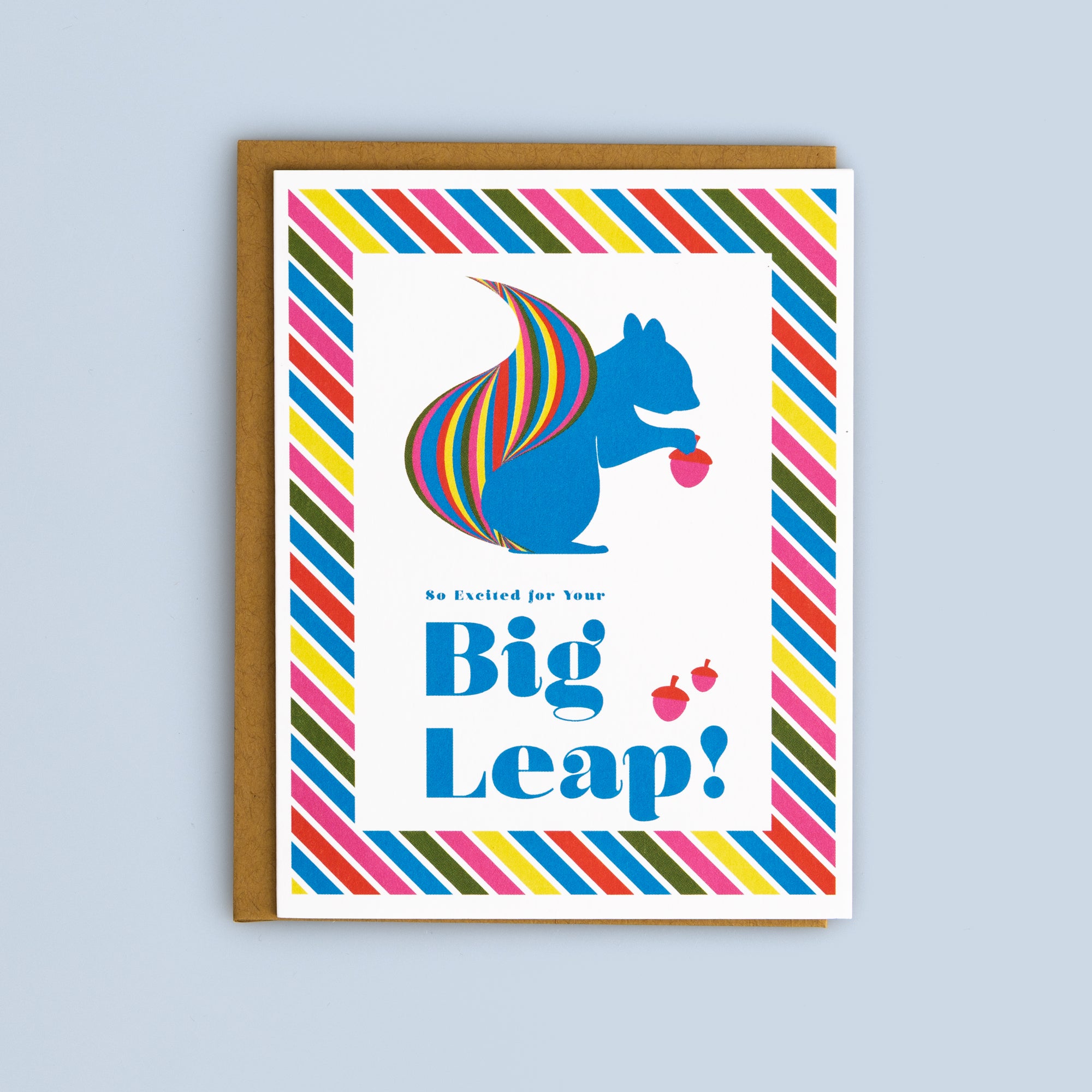 Bright Big Leap card featuring a blue squirrel with a rainbow-striped tail and colorful diagonal border, kraft envelope included
