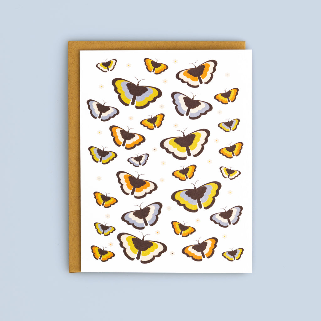 Flat card featuring colorful butterflies in yellow, orange, brown, and gray tones with a kraft envelope on a light blue background.