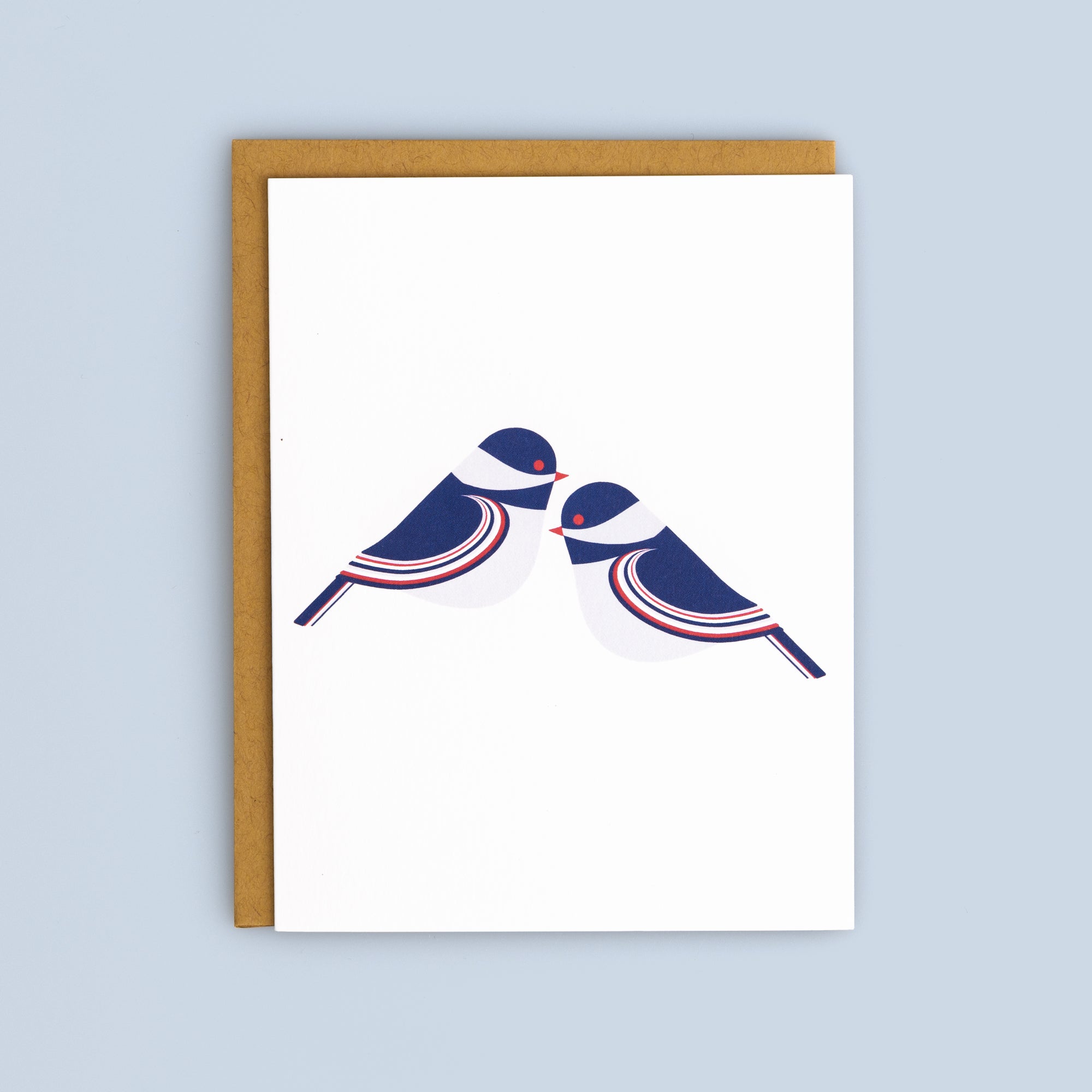 Flat card featuring minimalist blue and white birds facing each other with a kraft envelope on light blue background