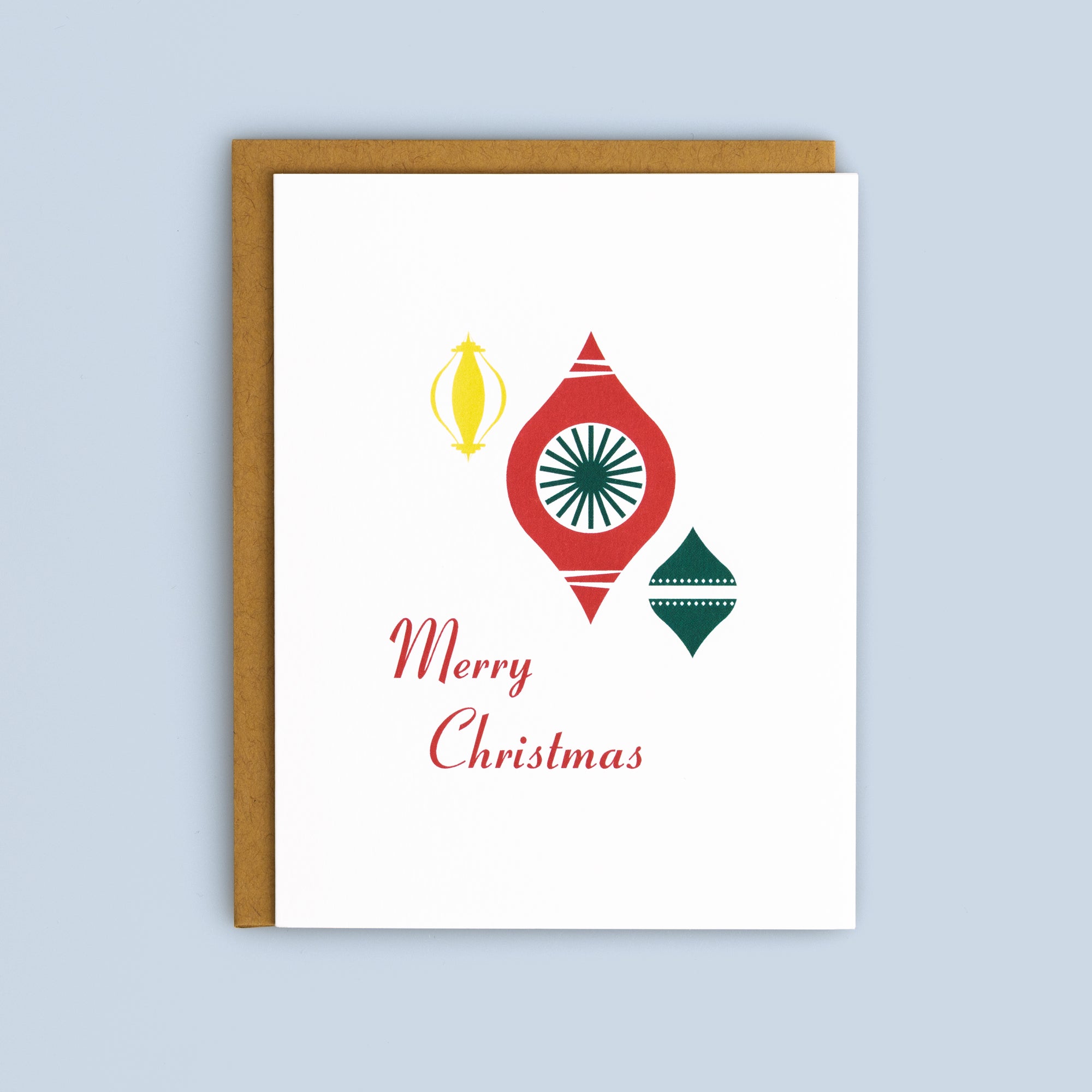 Flat Christmas card with red, green, and yellow retro ornament illustrations and "Merry Christmas" text, kraft envelope included