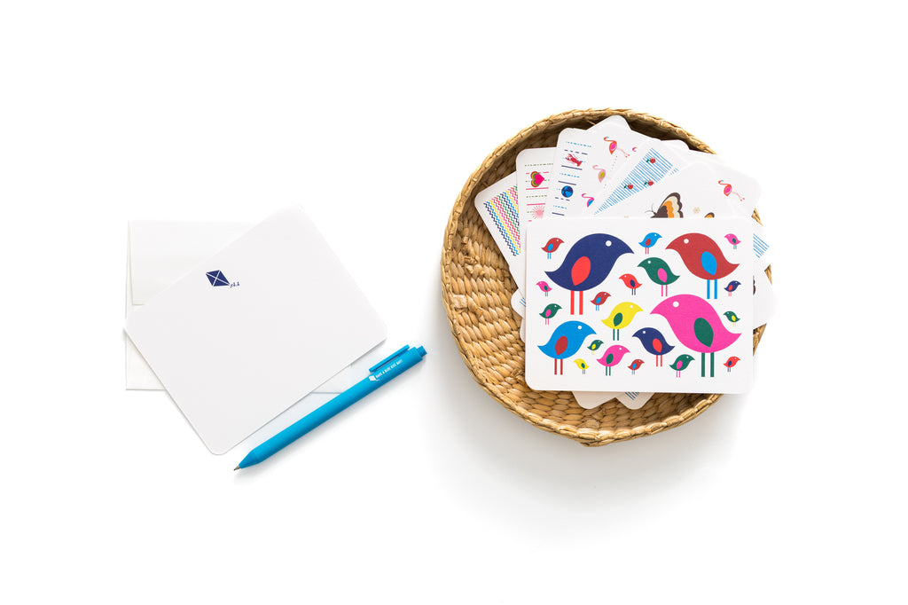 Set of 6 colorful kite-themed flat cards with coordinating envelopes and a blue pen on white background.