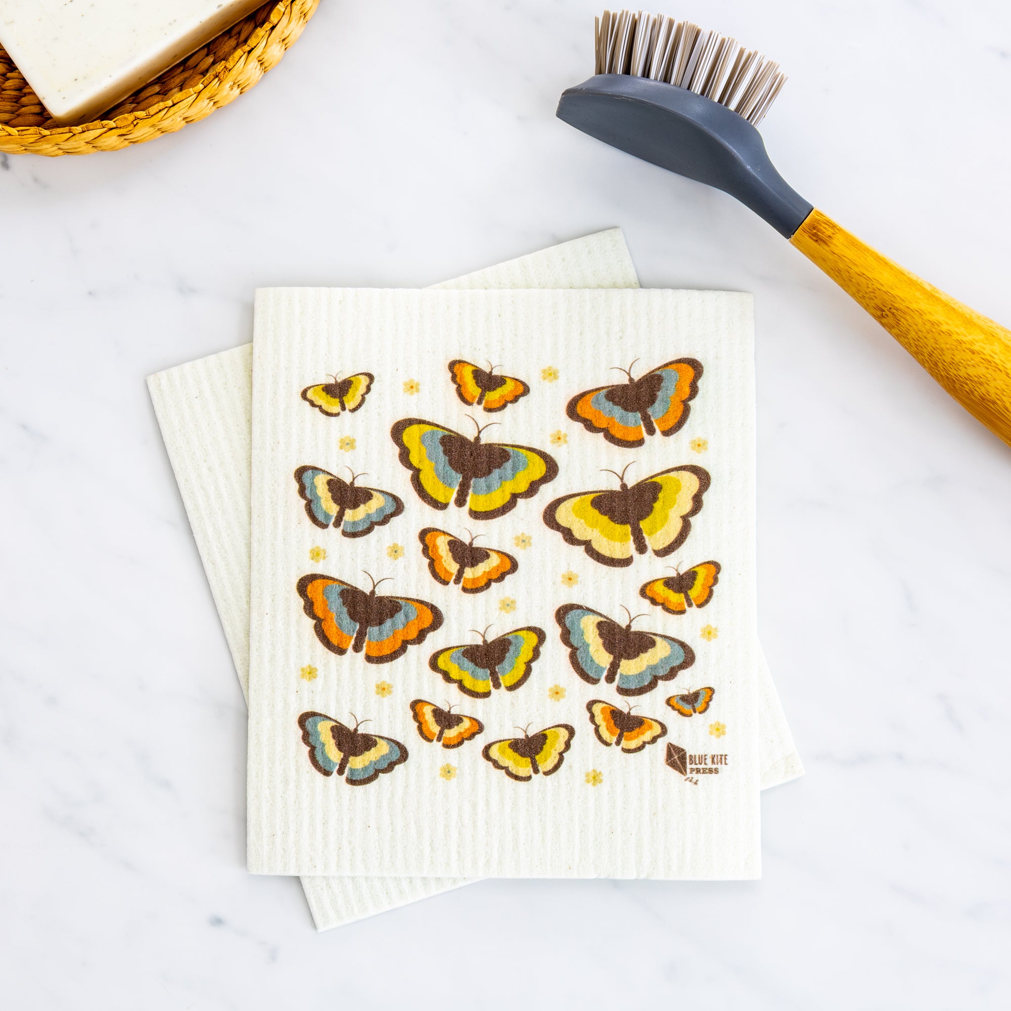 Butterfly Swedish Dishcloth with 70s boho design, eco-friendly reusable alternative to paper towels on white surface.
