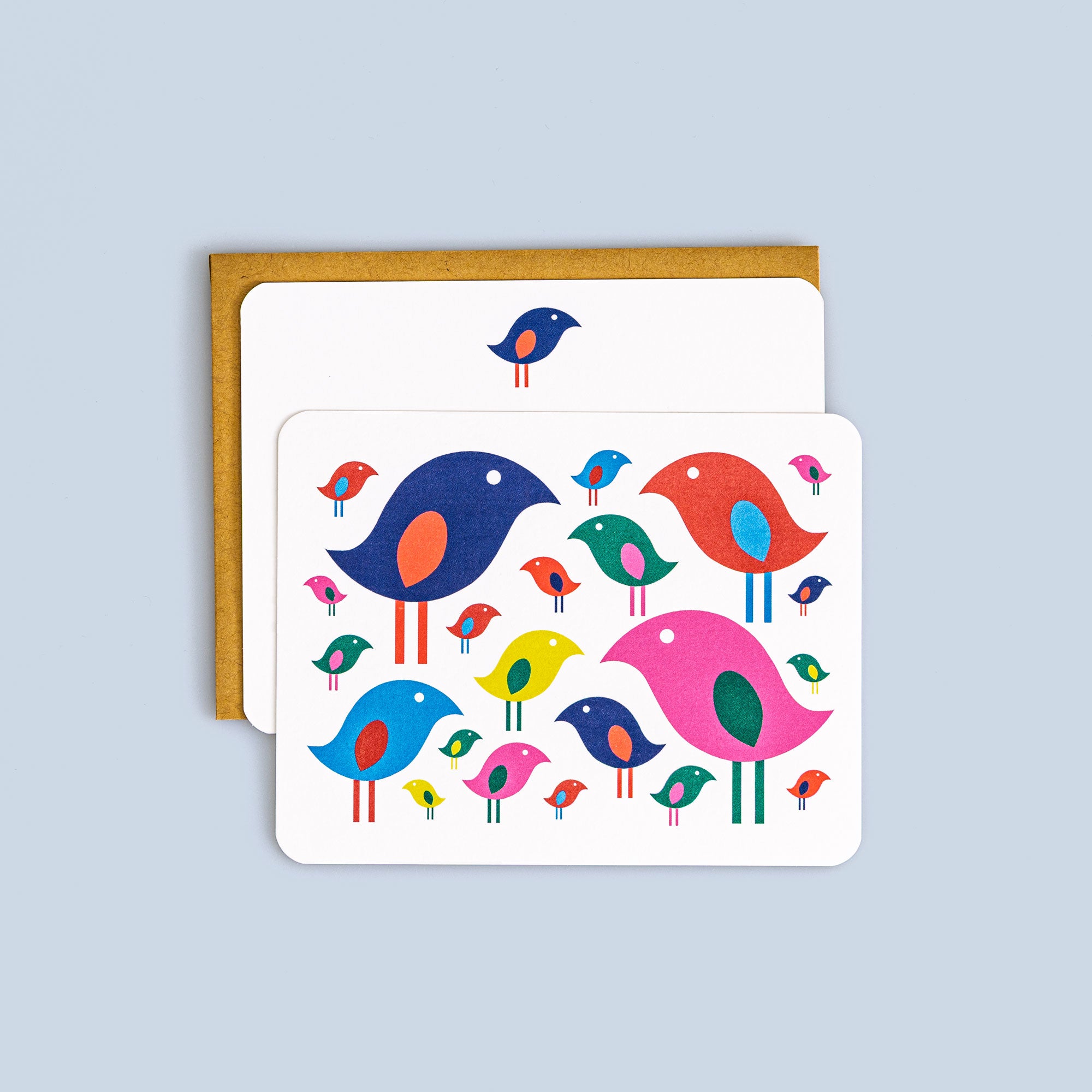 Flat card with colorful stylized birds in blue, pink, red, yellow, and green on white background with kraft envelope