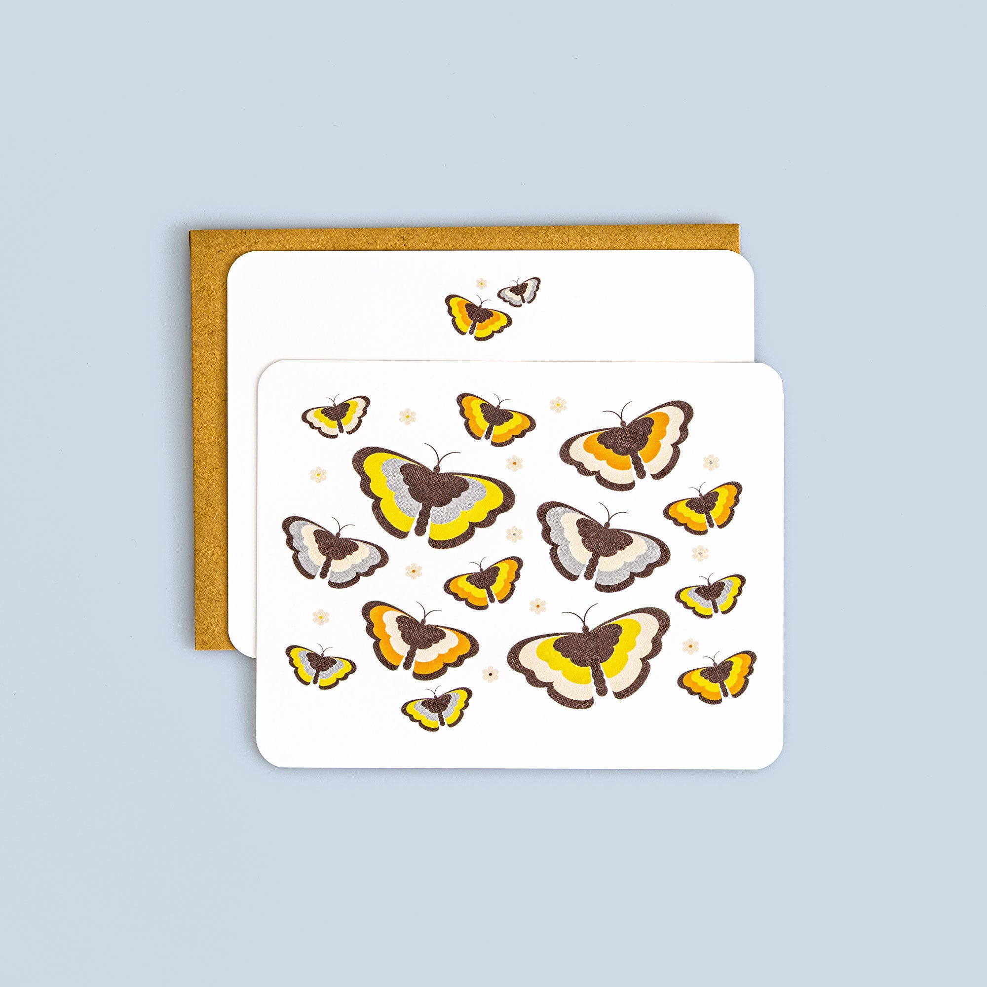 Flat card with yellow, orange, and brown vintage-style butterfly pattern and coordinating kraft envelope on light blue background
