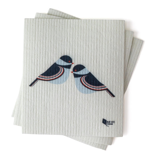 Eco-friendly Swedish dishcloths featuring stylized chickadee design in navy and light blue on white textured background, stacked to show product thickness and texture