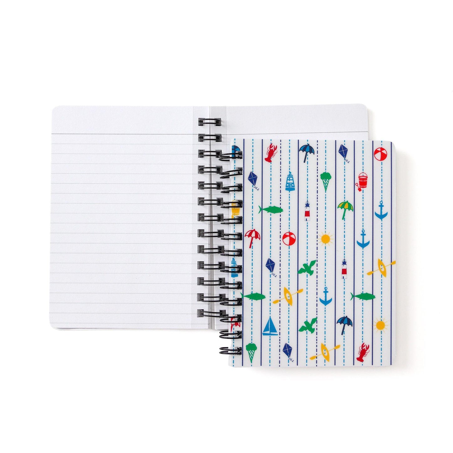 Spiral-bound notebook with colorful New England coastal pattern featuring sailboats, anchors, fish, and lighthouses on white cover, open to show blank lined pages