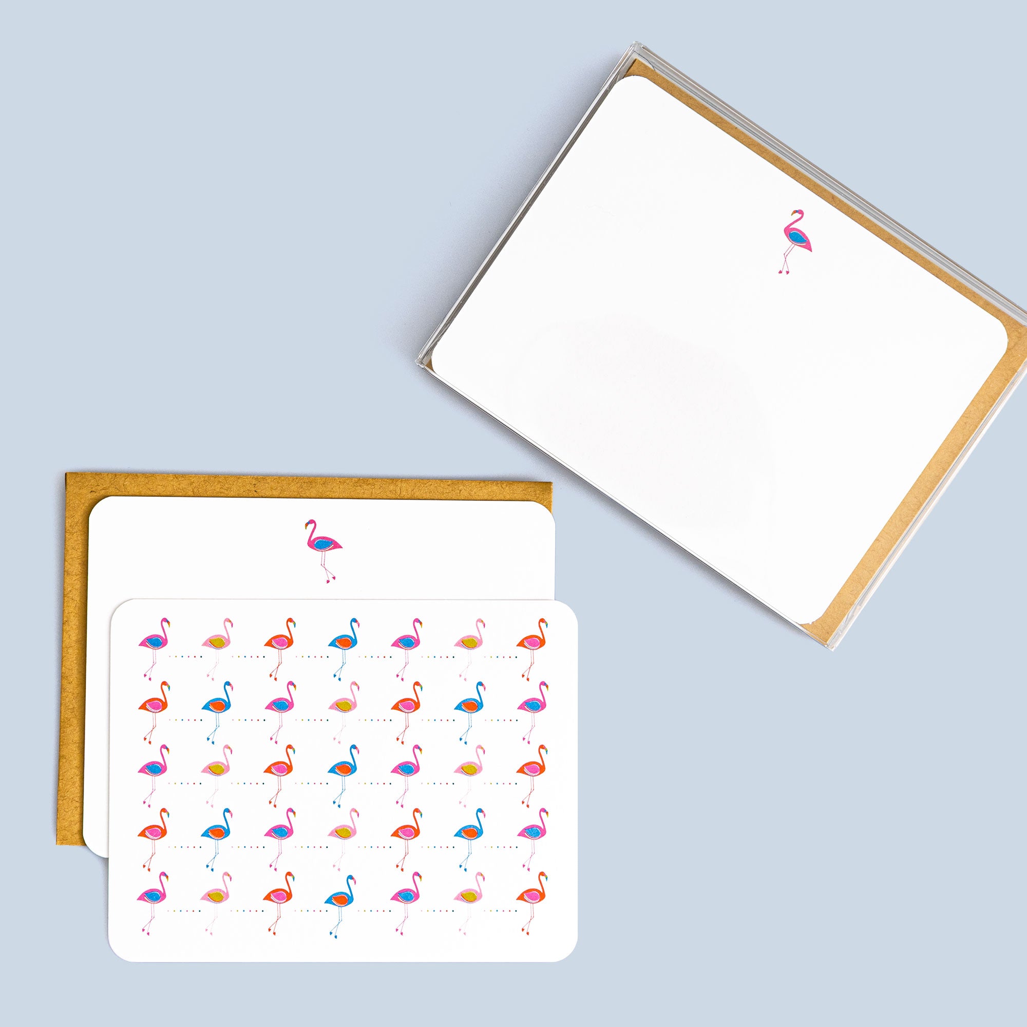 Box set of eight flat cards with colorful flamingo pattern and coordinating kraft envelopes on light blue background