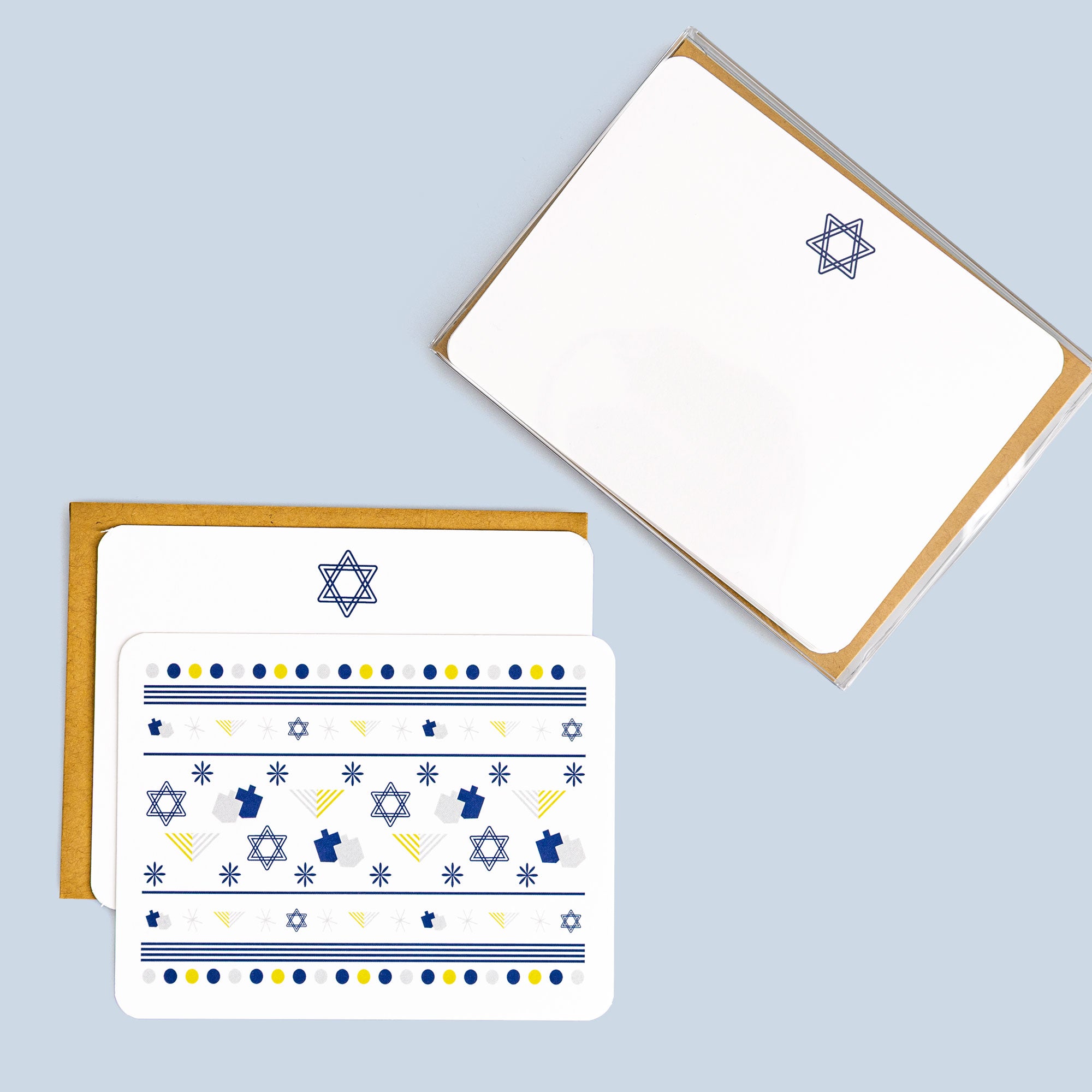 Set of eight Hanukkah flat cards with menorah and Star of David patterns, paired with kraft envelopes on light background