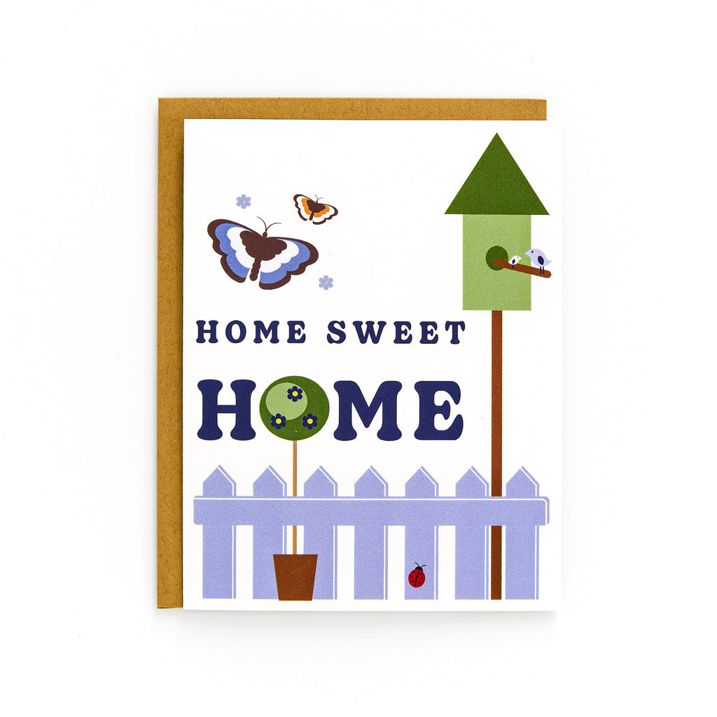 Home Sweet Home card with garden scene, butterflies, birdhouse, white picket fence, and kraft envelope on white background.