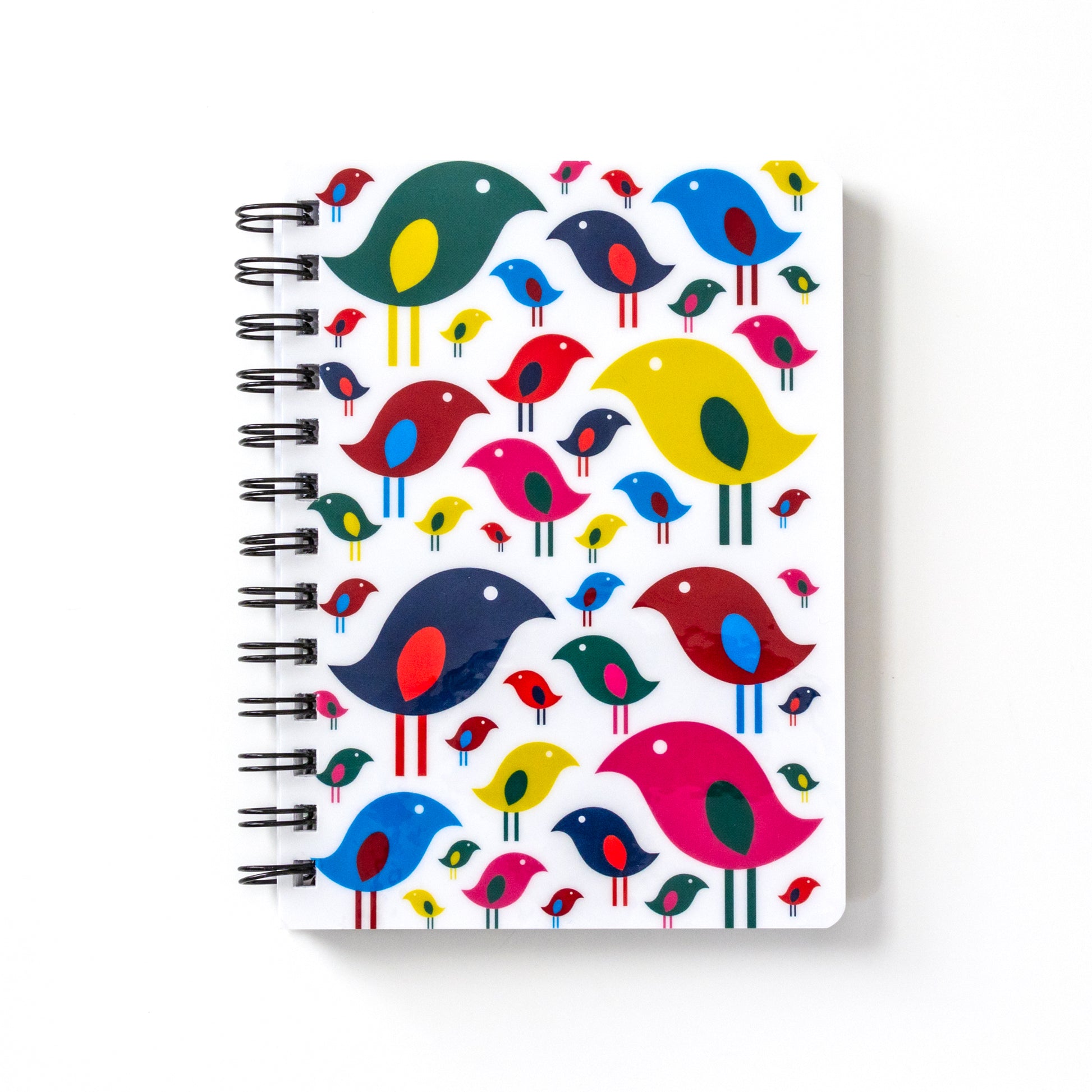 Spiral-bound notebook with colorful modern bird flock design on white cover, featuring stylized birds in various sizes and vibrant colors including red, blue, yellow, and pink, creating a cheerful and eye-catching pattern